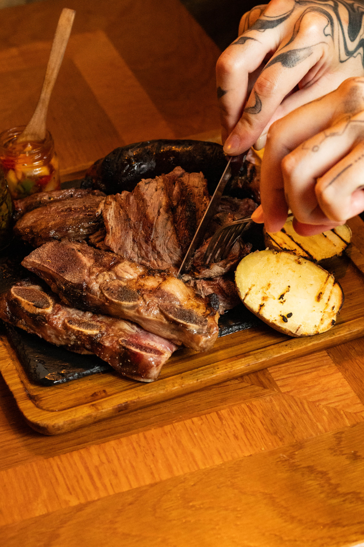Camarero cortando carne a la parrilla en la mesa